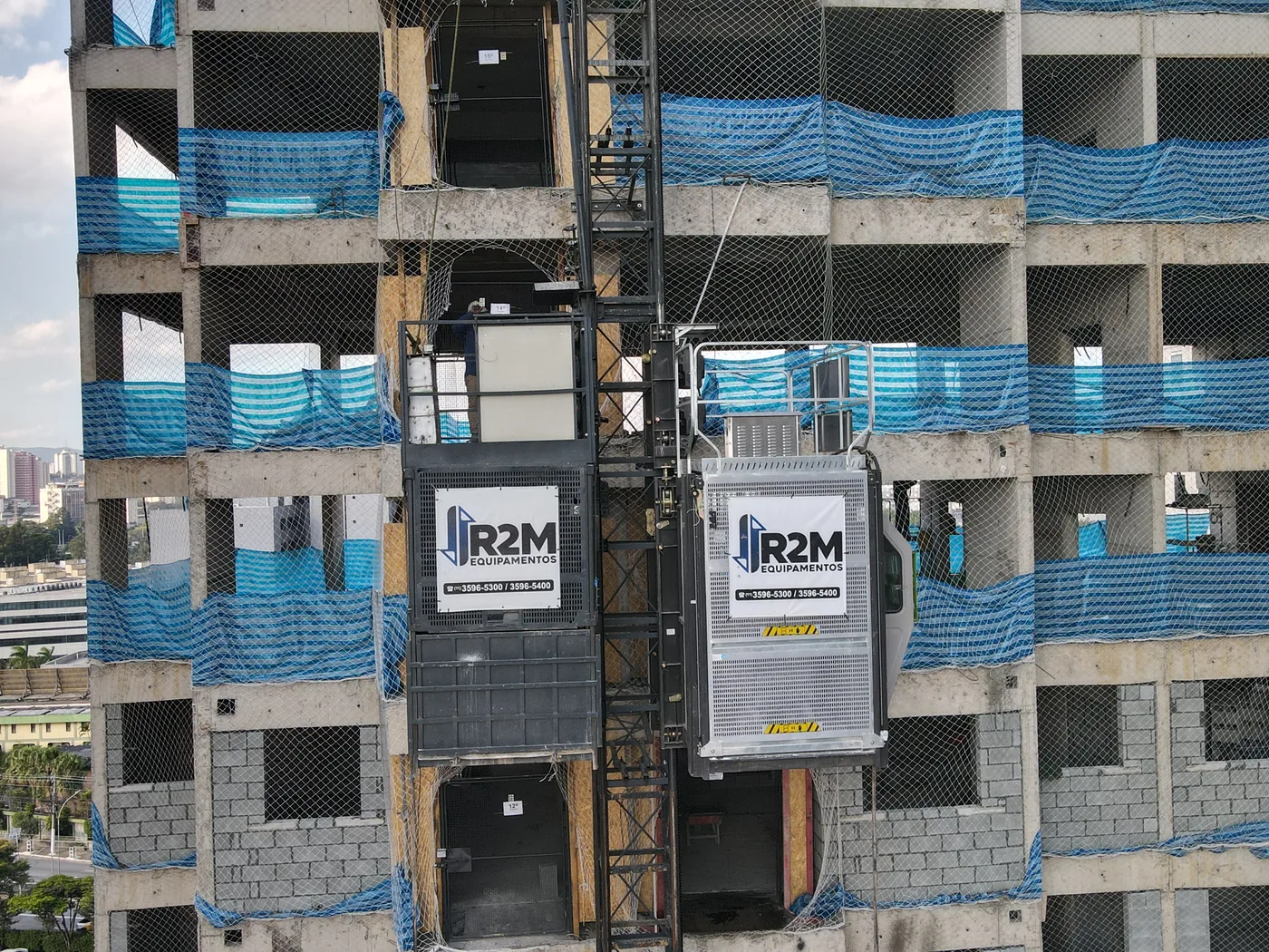 Cabine R2M em obra com telas de proteção azuis