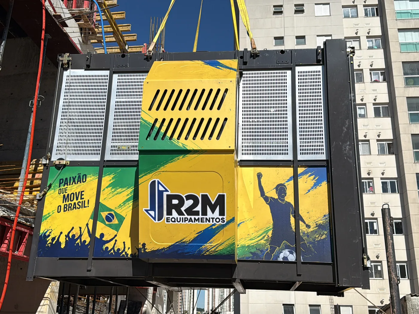 Cabine personalizada da campanha da R2M sendo içada