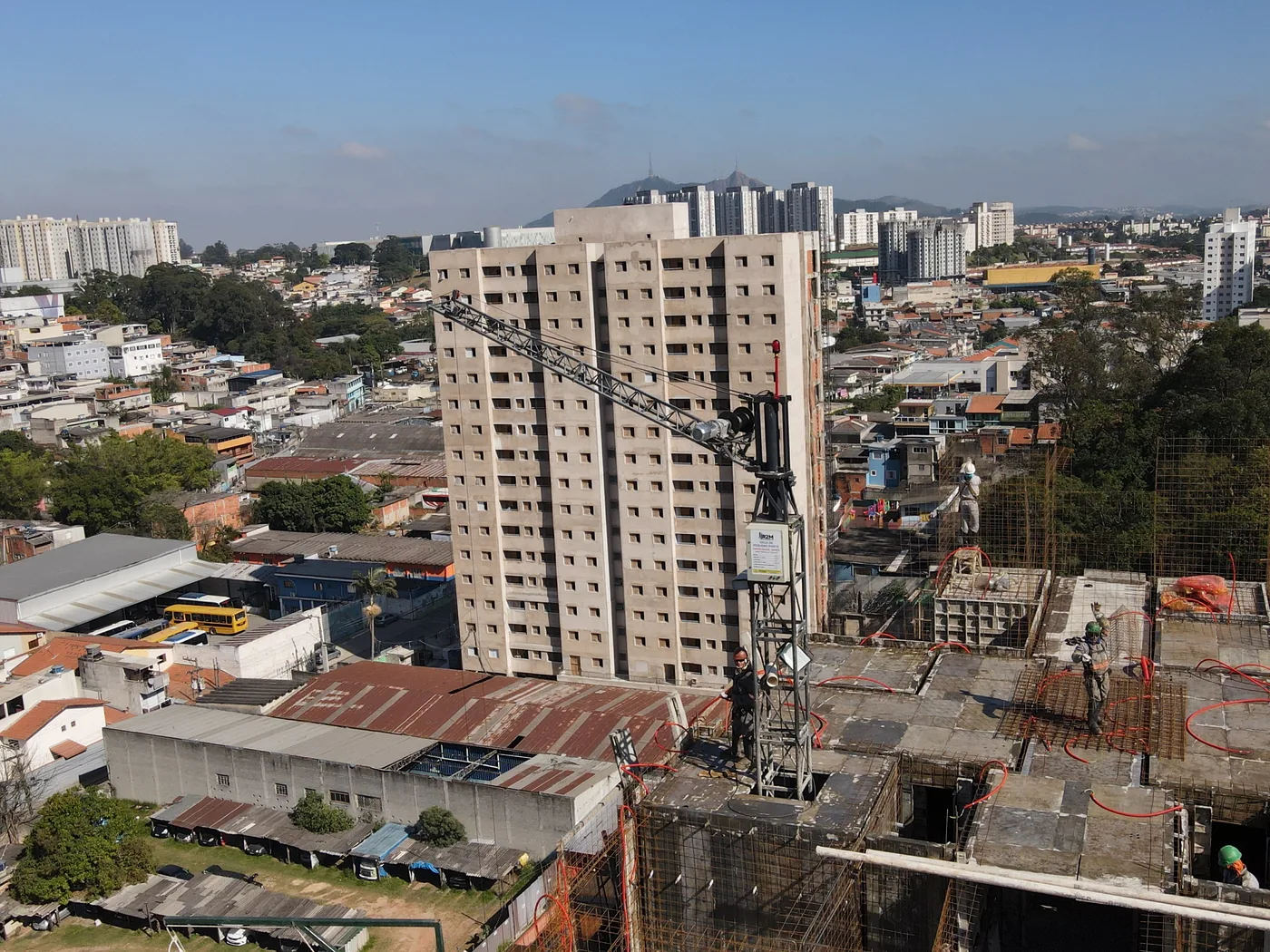 Grua de Pequeno Porte em obra urbana com edifícios ao fundo